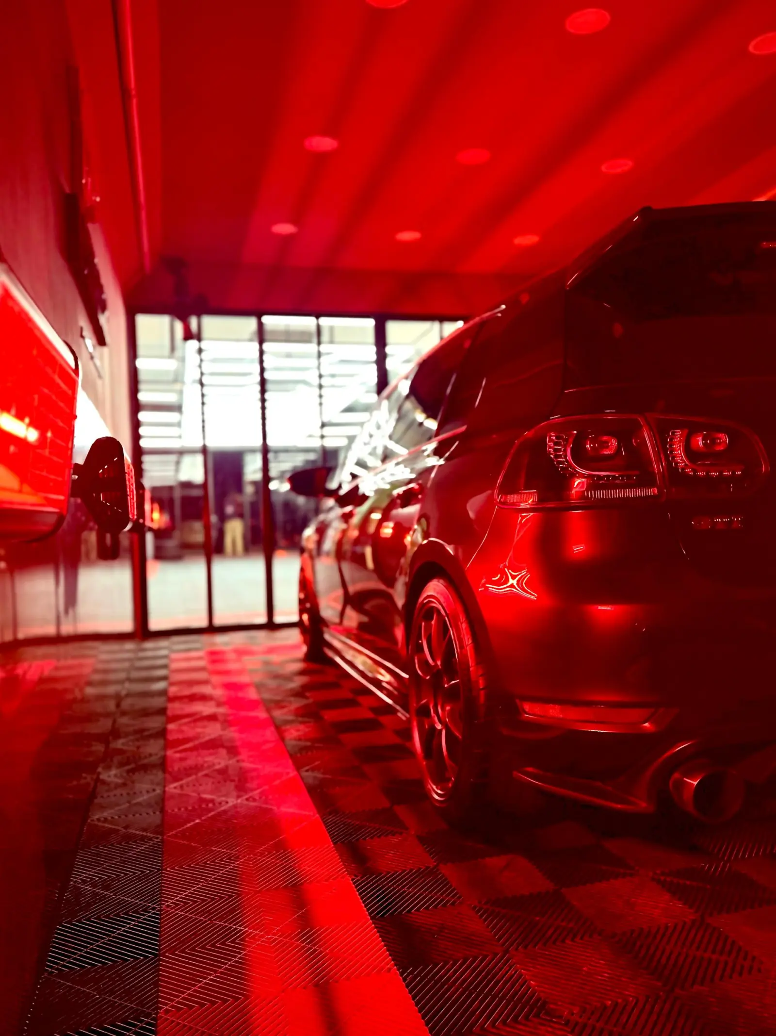 Dedicated infrared curing room bathing a Golf GTI in red light